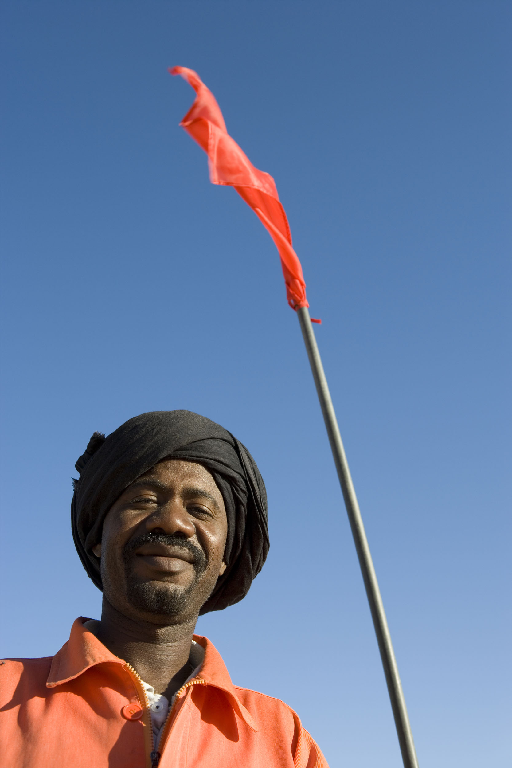 Portrait en contre-plongée d'un homme au travail sur un site de prospection et d'exploration de pétrole en Mauritanie. Client : Total Exploration Production