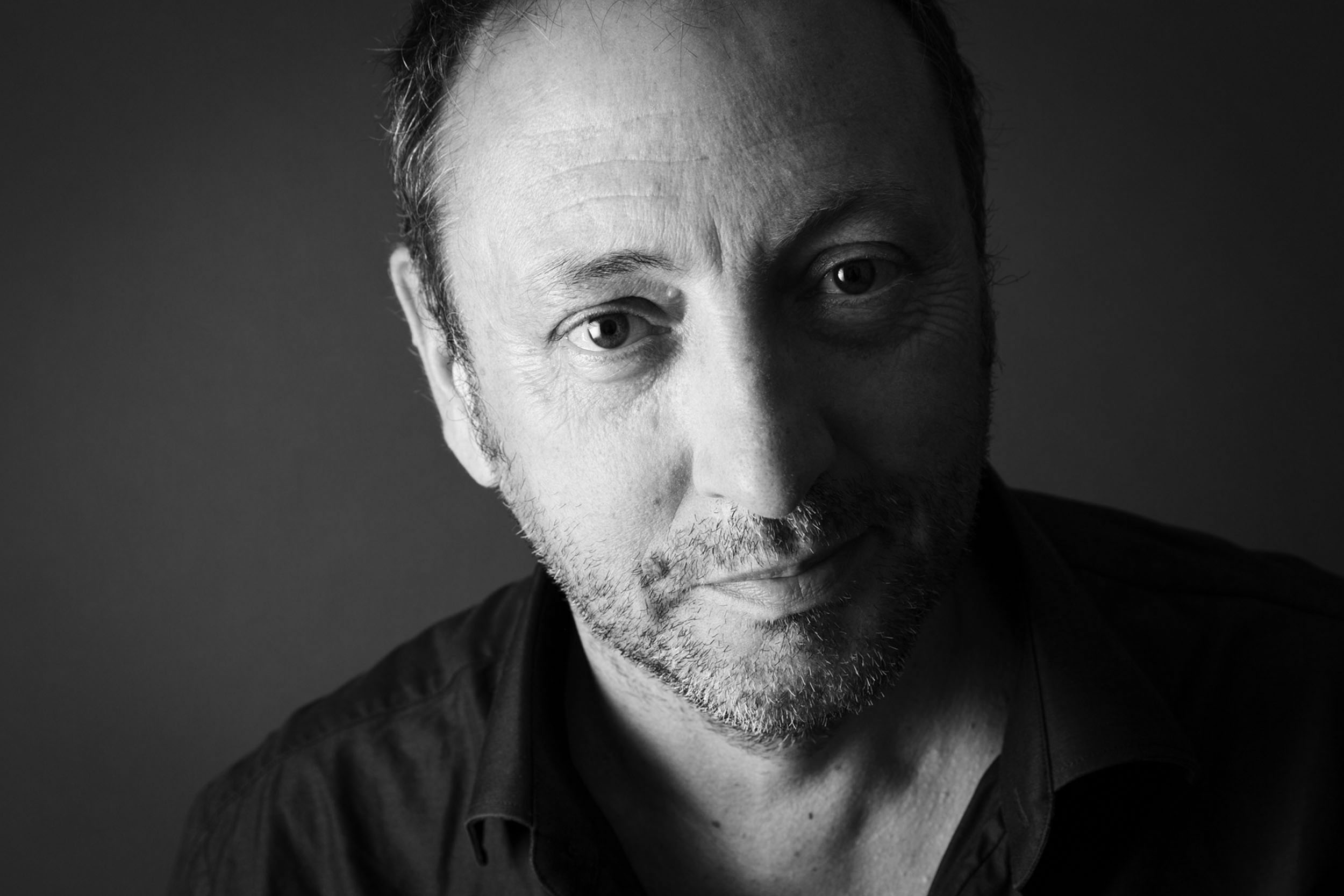 Portrait réseaux sociaux en noir et blanc du paysagiste Thierry Jourd'heuil. Photo de portrait réalisée en studio sur fond gris. Cadrage du portrait en gros plan.