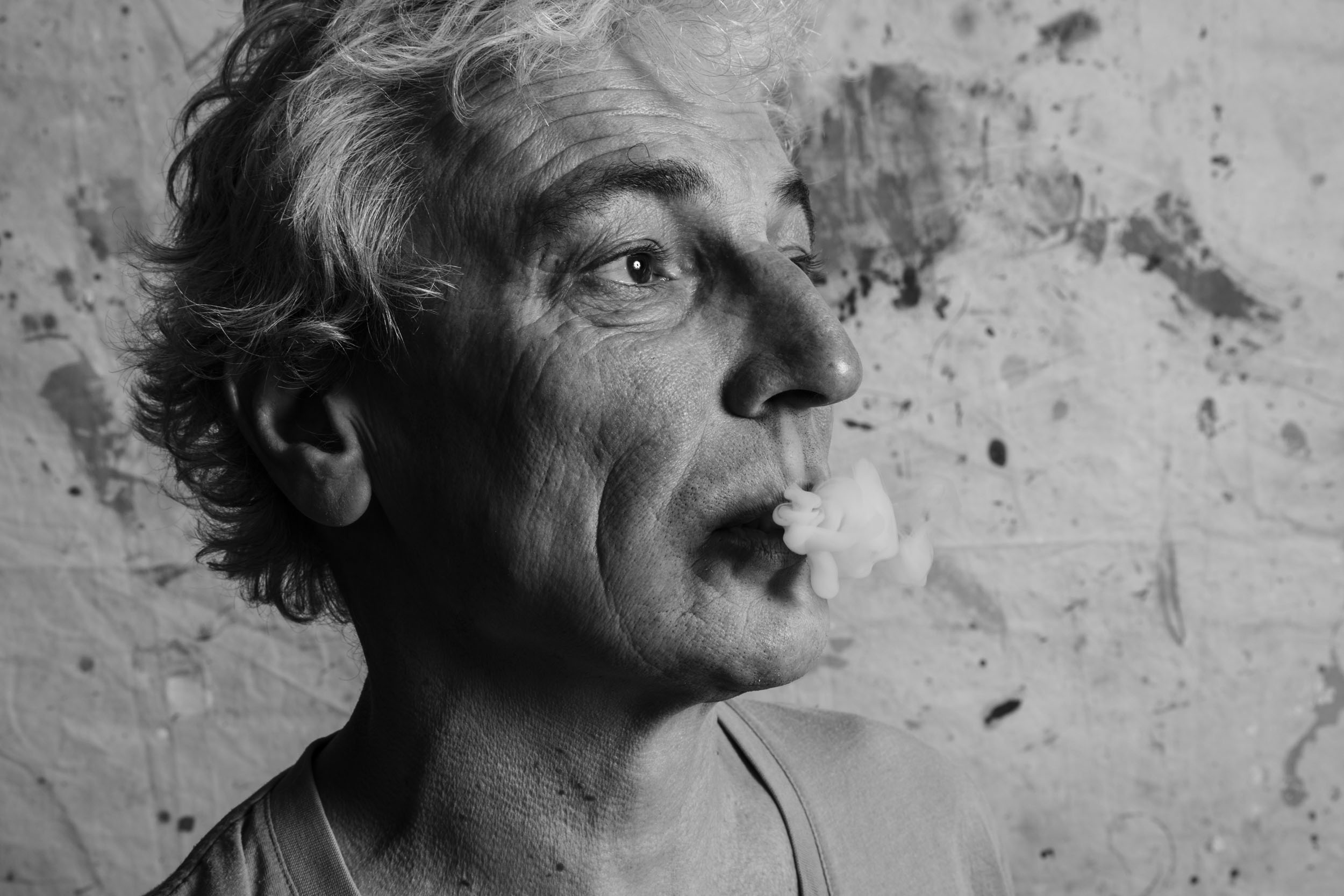 Portrait artistique d'un homme en studio sur fond de bâche peinte. Photo de portrait en noir et blanc.