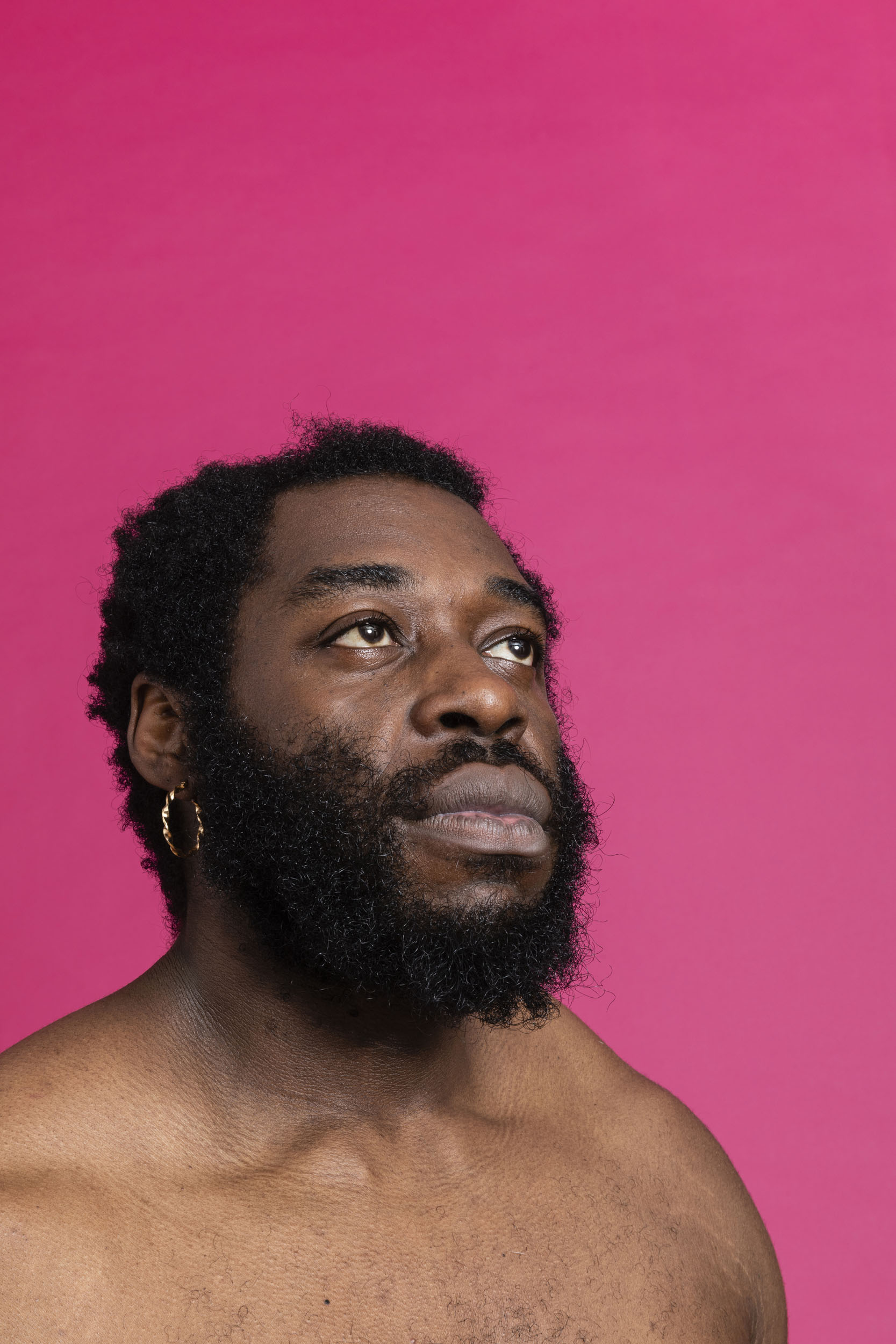 Portrait d'un homme noir torse nu sur fond rose. Photo de portrait, un autre regard,  réalisée pour la banque d'images Plainpicture.