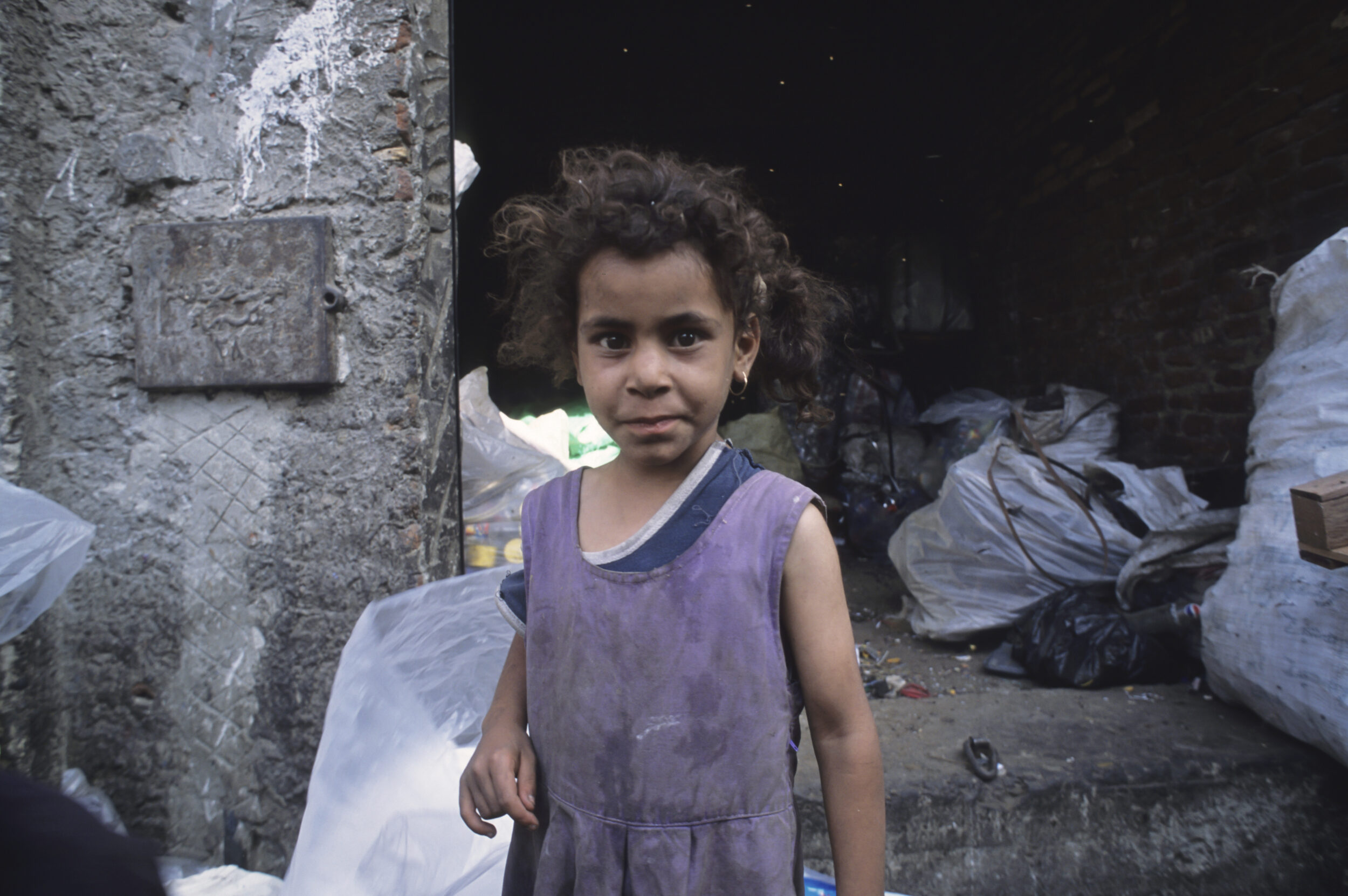 Portrait posé d'une enfant chiffonnière dans la rue, quartier du Mokattam au Caire.