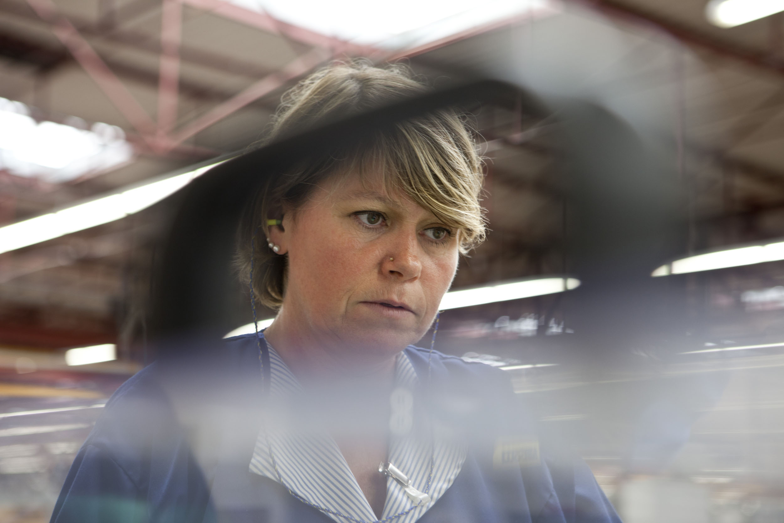 Portrait d'une femme au travail dans les ateliers de fabrication du Groupe Hamelin. Reportage photo commandé par l'entreprise.