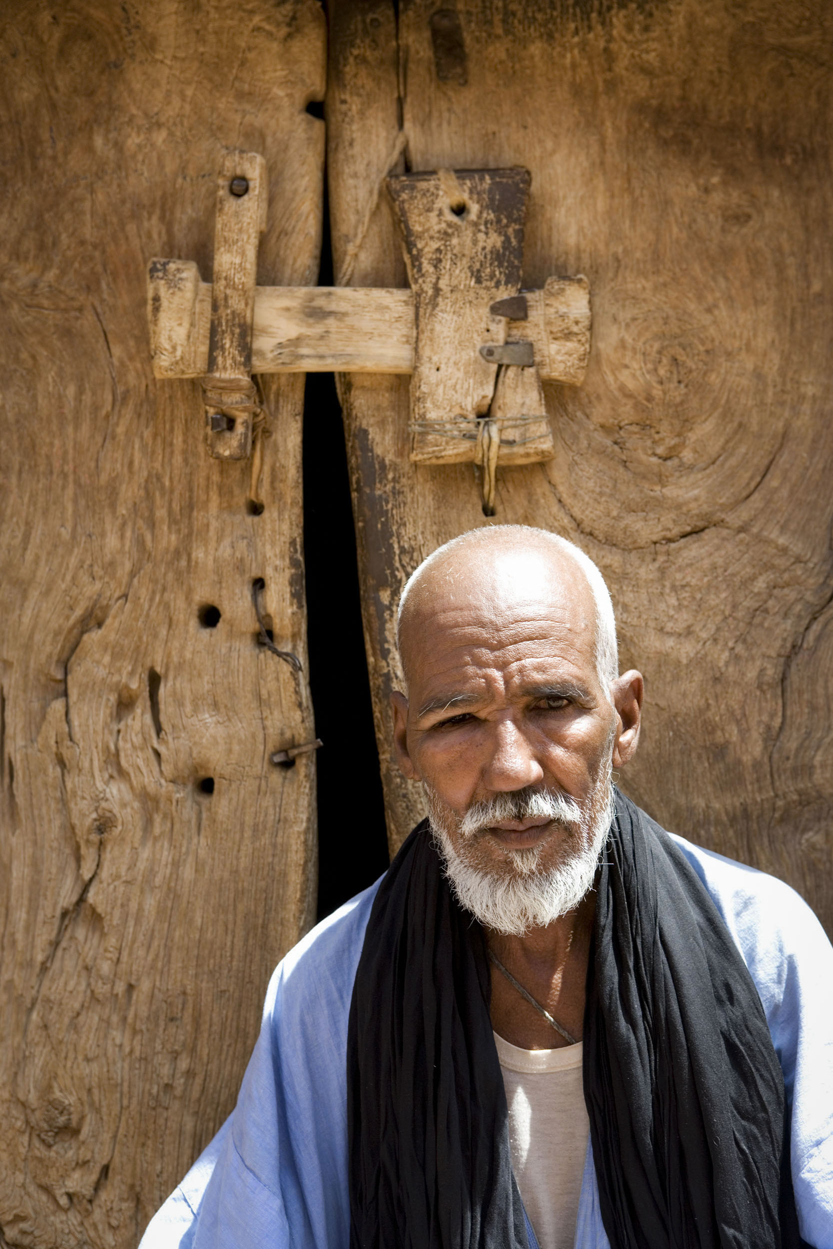 Portrait d'un homme devant la porte de sa maison en Mauritanie. Photo de commande réalisée pour la division exploration production du Groupe Total.