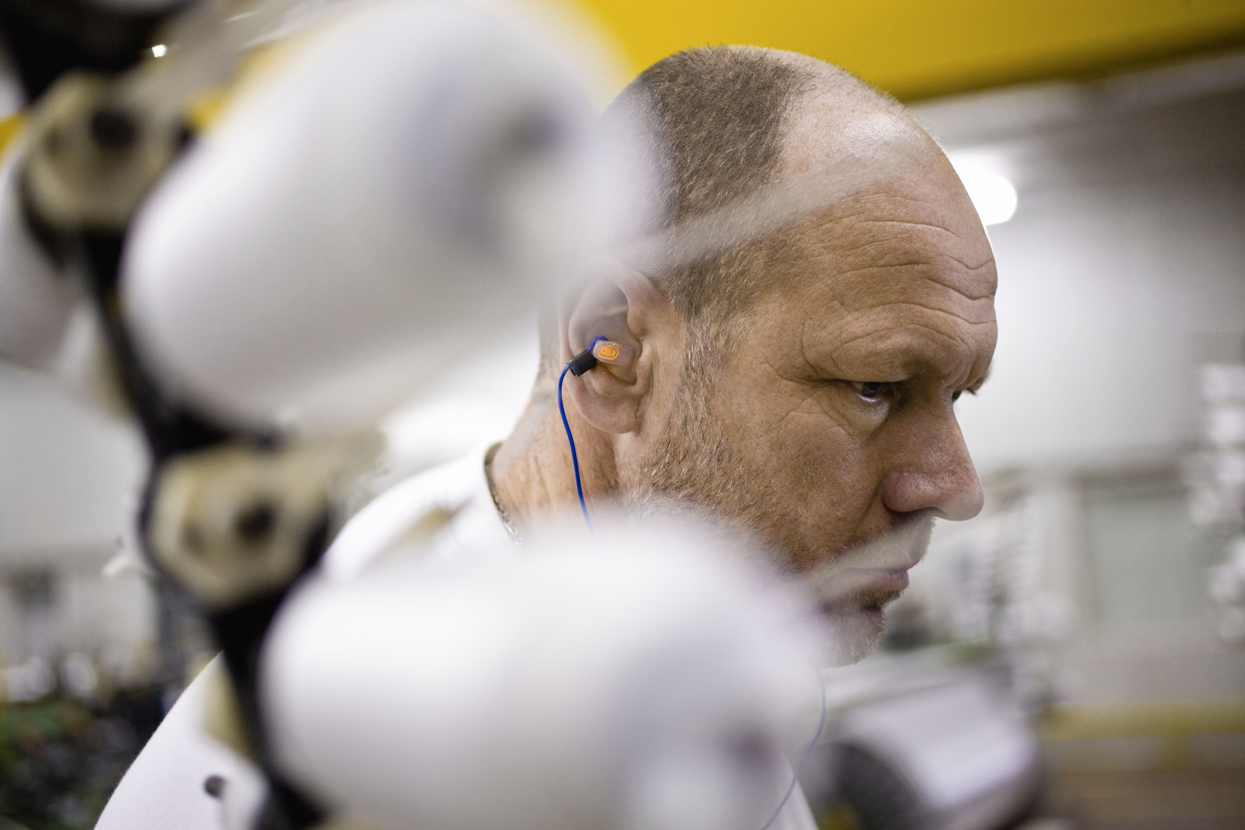 Portrait d'un homme au travail dans un atelier de fabrication de textiles intelligents. Reportage commandé par le Groupe Serge Ferrari.