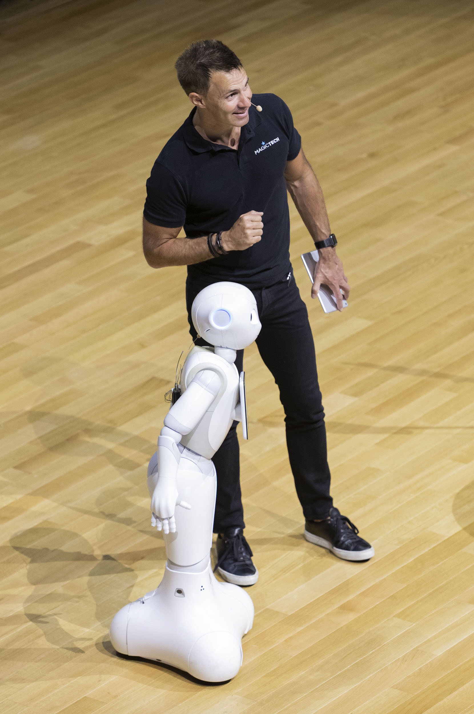 Photographie de portrait d'un intervenant sur scène avec le robot Pepper lors d'une convention de la société Cerfrance.