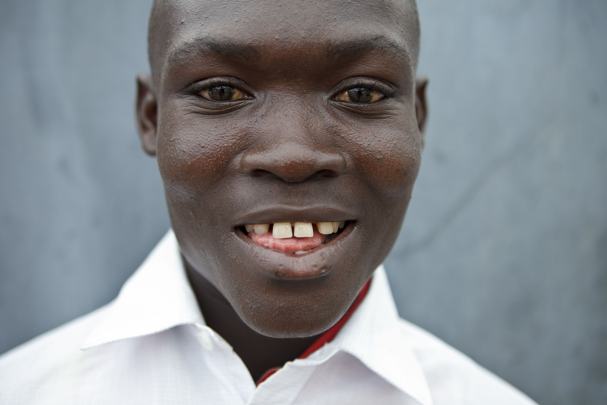Portrait d'un jeune garçon en Côte d'Ivoire. Reportage commandé par la marque  Nescafé® du Groupe Nestlé®. Photo de portrait en gros plan réalisée en lumière naturelle.