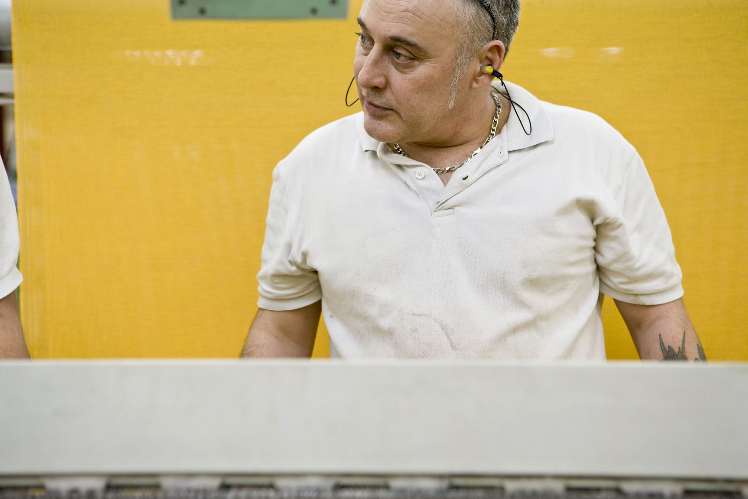 Portrait d'un homme au travail devant un métier à tisser. Photo de portrait commandée par le Groupe Serge Ferrari.