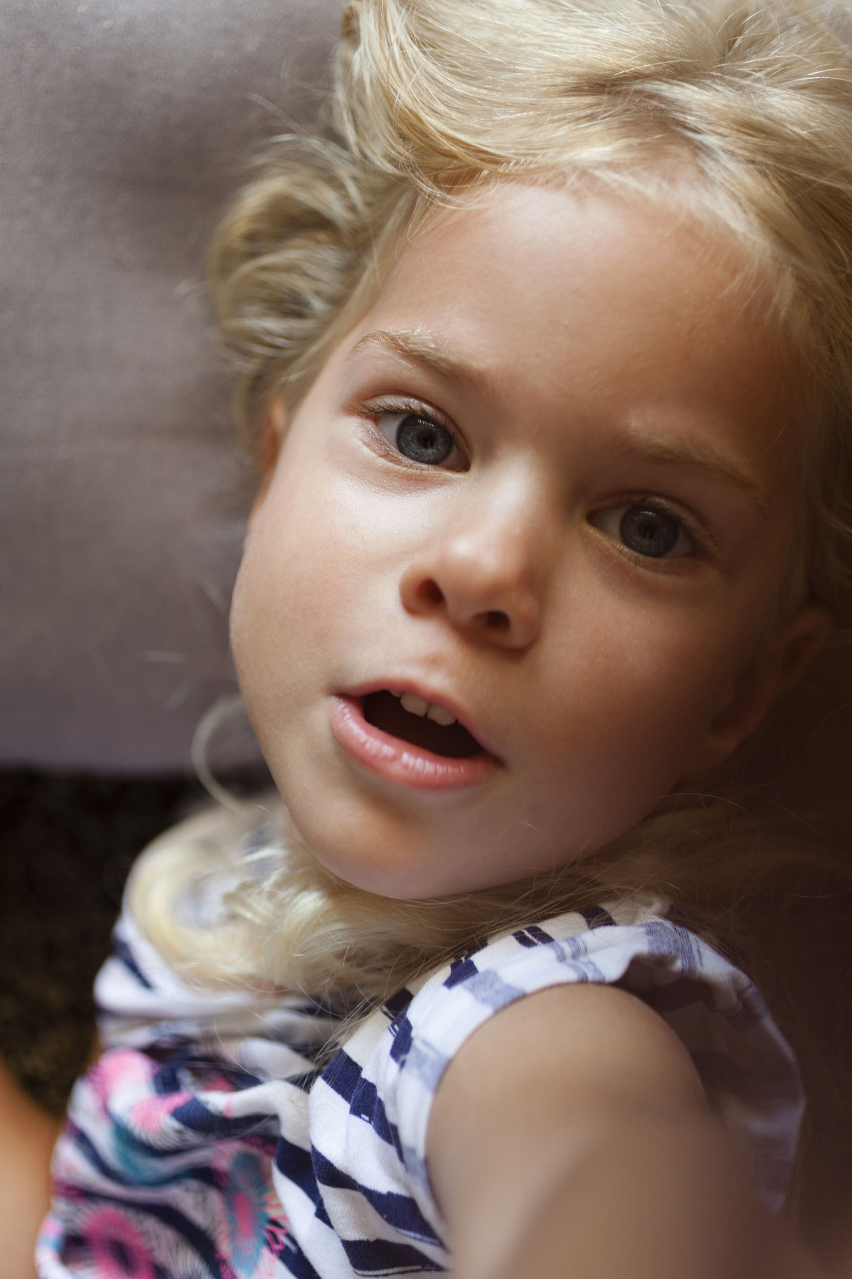 Portrait en gros plan d'une enfant aux cheveux blond vue du dessus. Photo de portrait, un autre regard,  réalisée pour la banque d'images Plainpicture.