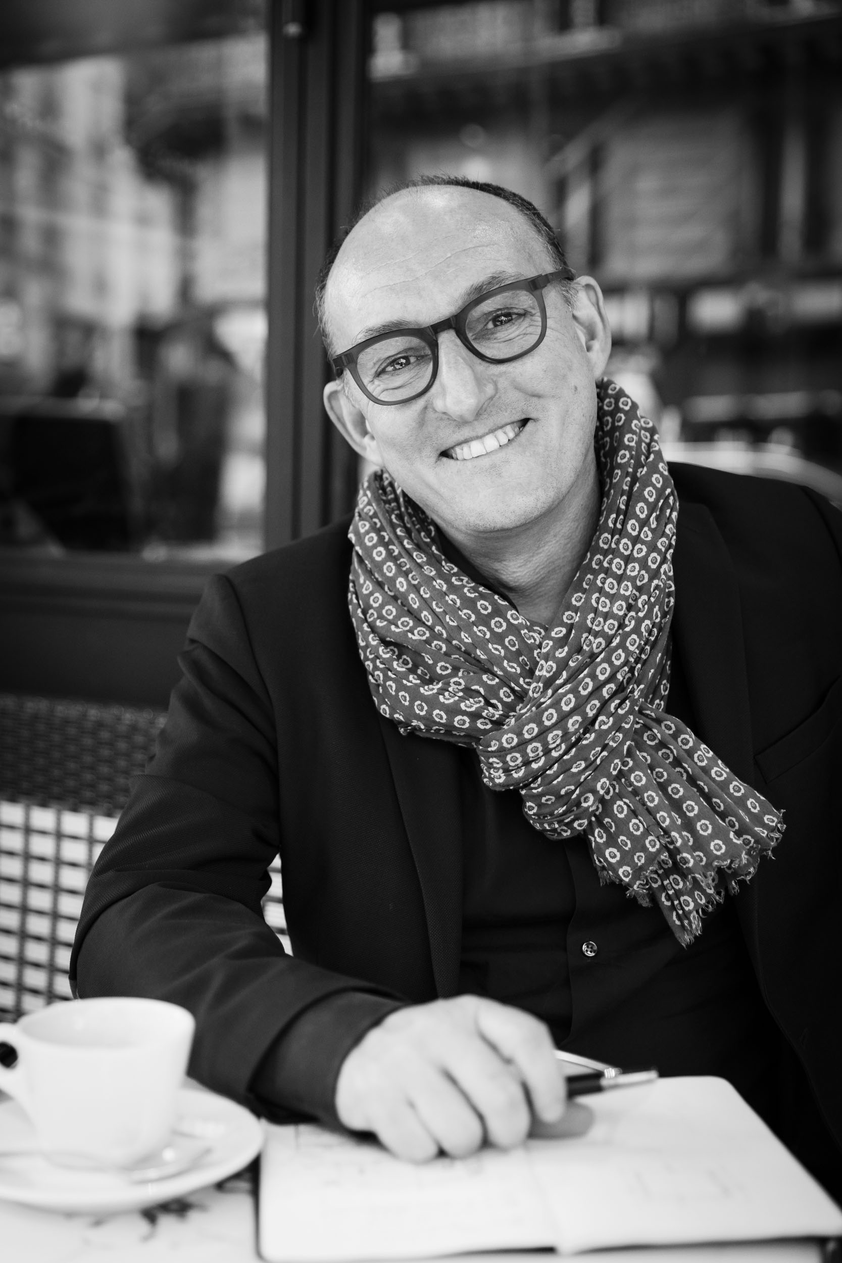 Portrait de l'architecte d'intérieur Yann Montfort assis à la terrasse d'un café parisien.