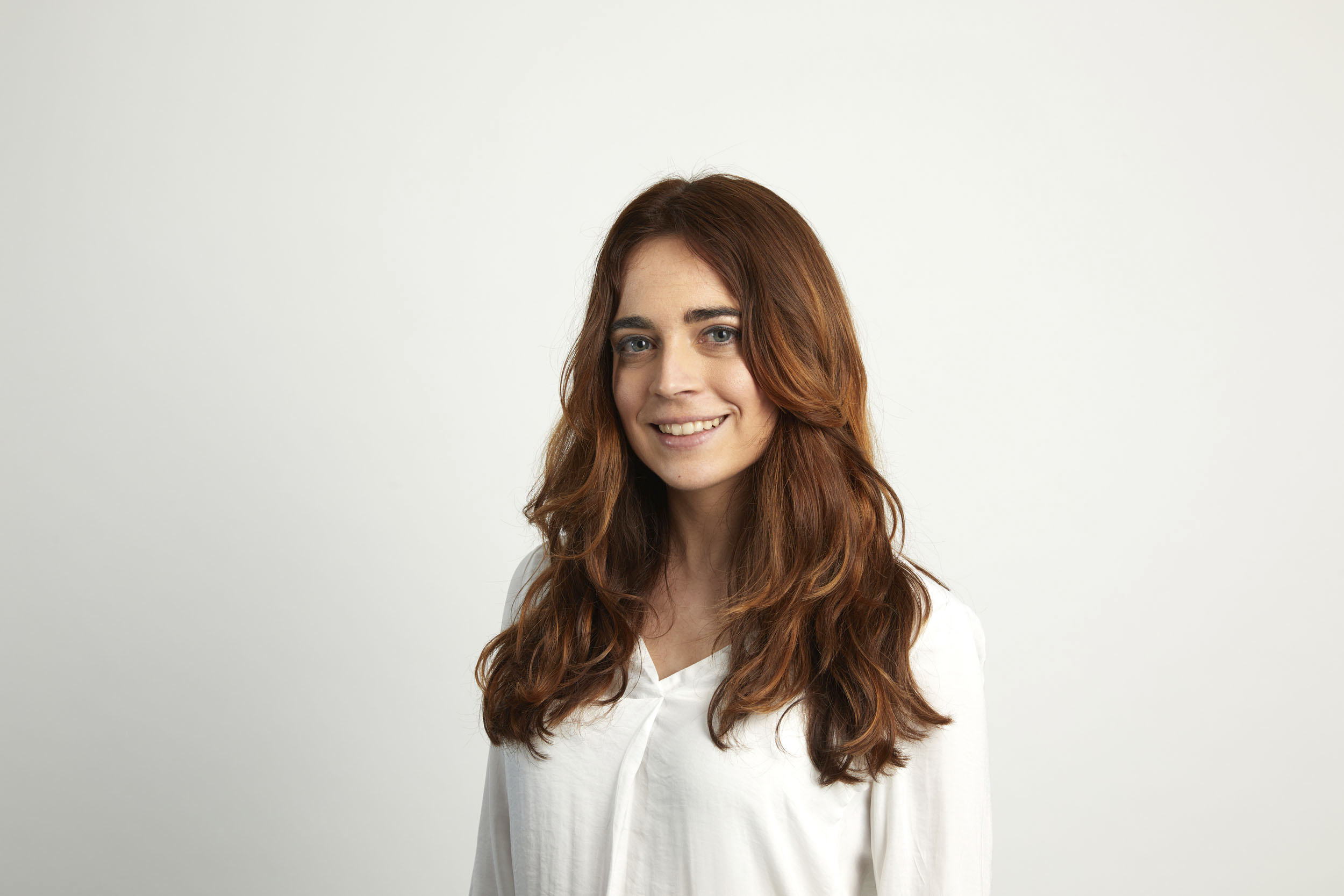 Portrait corporate d'une femme aux cheveux longs réalisé en studio mobile sur fond blanc. Photo de portrait commandée par la société GRTgaz.